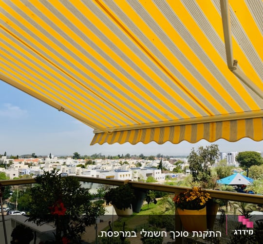 סוכך פסים צהוב ולבן במרפסת